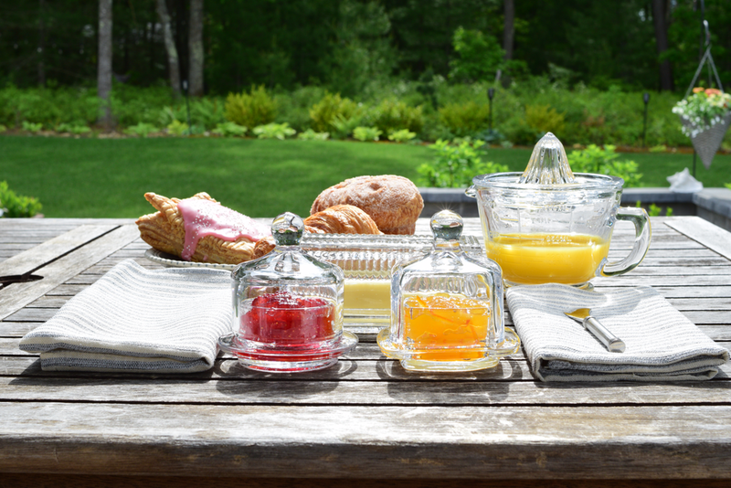 Earth & Nest | Round Cloche Condiment Dish displaying jams and juices on a table, ideal for showcasing condiments or fruits at gatherings.