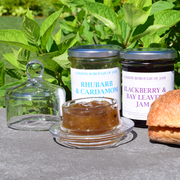Round Cloche Condiment Dish showcasing jam in a glass jar beside a sandwich, highlighting its versatility for displaying various condiments.
