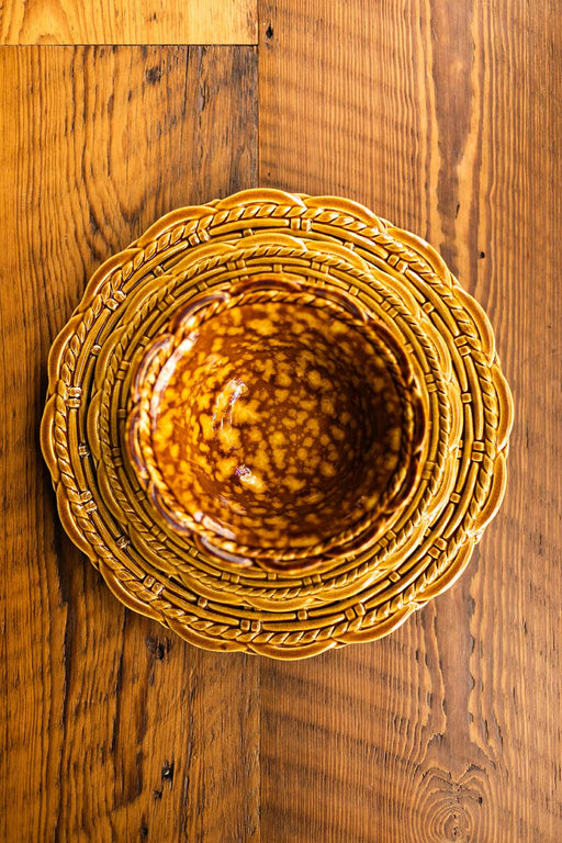 Provvista Designs | Basket Jubilee Cereal Bowl in Honey Tortoise, featuring a scalloped rim and braided border plate, on a wooden table.