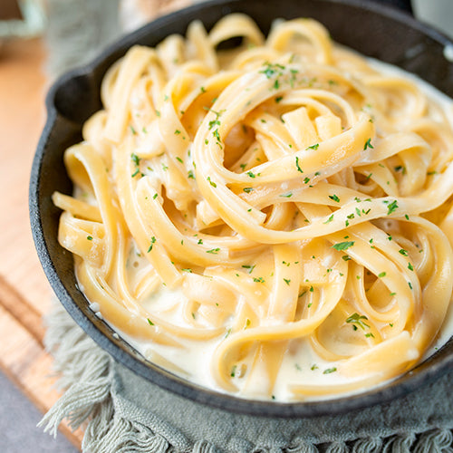 Fresh fettuccine in Alfredo sauce, garnished with parsley, highlighting the Gnocchi Two Ways: A Hands-On Pasta Night class at Athens Cooks.