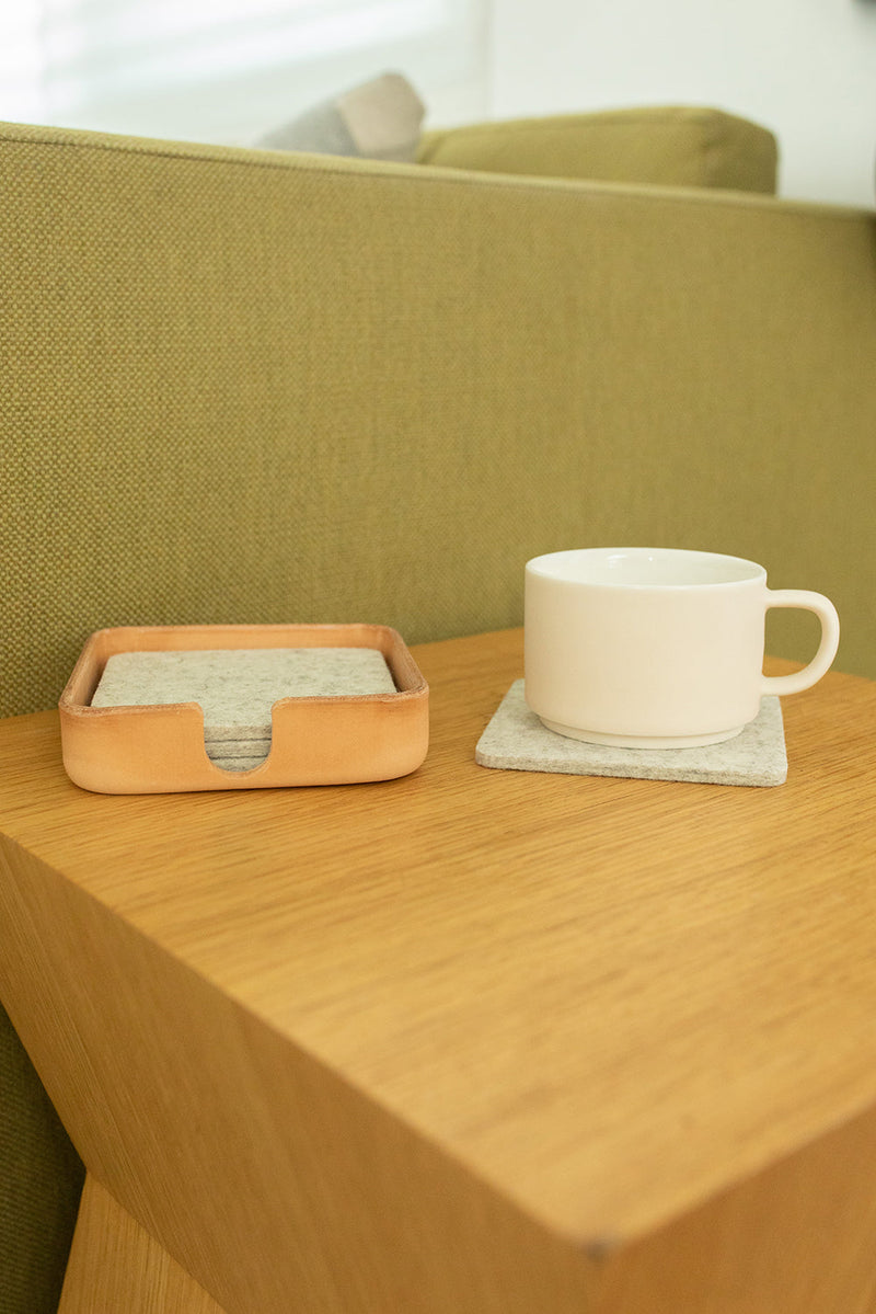 Graf Lantz Kobon Leather Square Tray holding a white mug and coasters on a table, showcasing its versatility and elegant design.