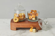 Etú Home| Bistro Bon Bon Jar displayed on a wooden board, showcasing its Depression-era inspired design, perfect for storing cookies or confections in a kitchen setting.