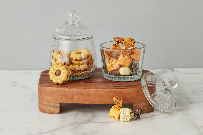 Etú Home| Bistro Bon Bon Jar displayed on a wooden board, showcasing its Depression-era inspired design, perfect for storing cookies or confections in a kitchen setting.