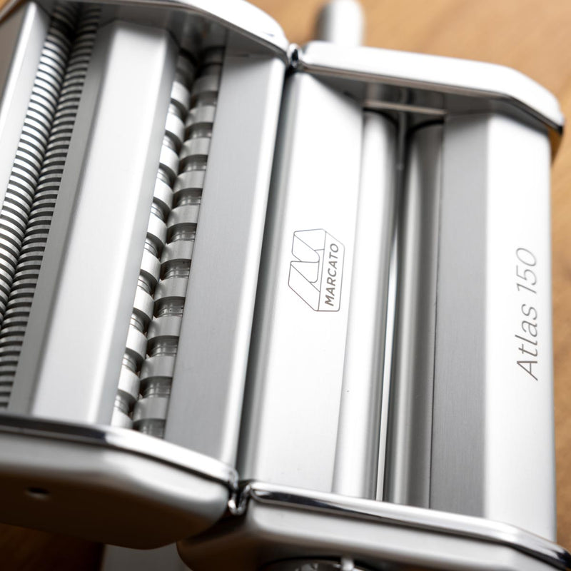 Marcato | Atlas 150 Pasta Maker (Ice) displayed with rollers and adjustable dial for making lasagne, fettuccine, and tagliolini, highlighted for its precision in homemade pasta crafting.