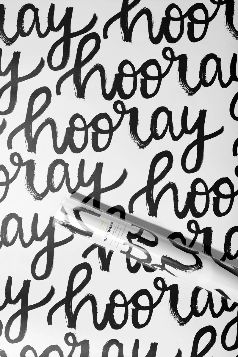 The Paper Curator | Gift Wrap - Merry features elegant black calligraphy on white satin paper, sized at 20 x 29, perfect for any occasion.