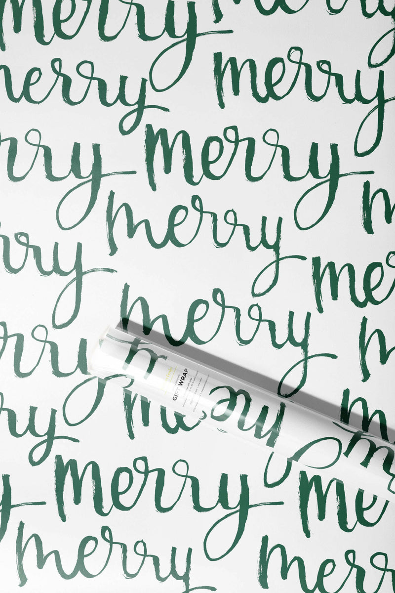 The Paper Curator | Gift Wrap - Merry: A roll of gift wrap featuring elegant green calligraphy on white satin paper, designed for versatile, festive occasions.