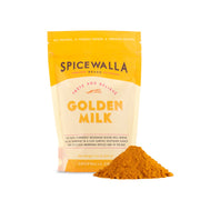 Spicewalla | Golden Milk, Resealable Bag, beside a mound of bright yellow spice blend, turmeric-based for antioxidant-rich beverages with ginger, nutmeg, and coriander.