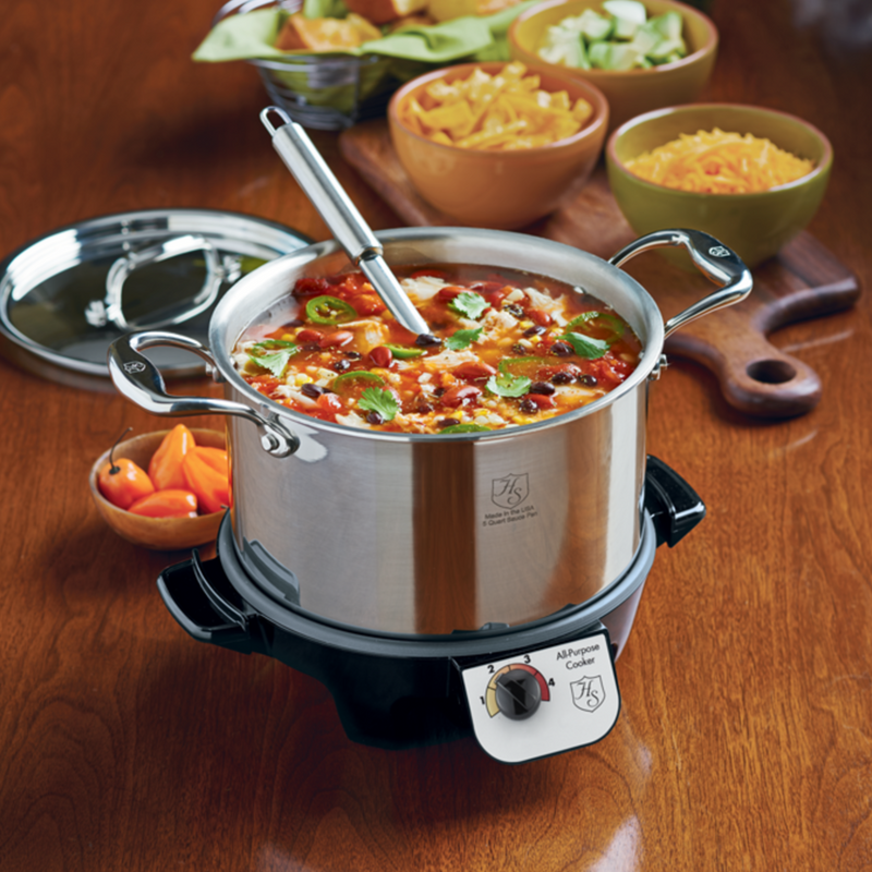 Heritage Steel | Titanium Series 5 QT Stock Pot with Lid on table, surrounded by bowls of food, showcases its versatility for soups and stews.