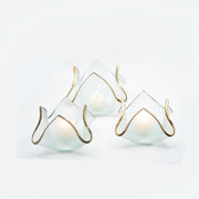 Annie Glass | 7 x 7 x 5 XL Handkerchief Votive, featuring frosted-glass with a gold-trimmed, petal-like shape, beautifully illuminated by lit tealight candles.