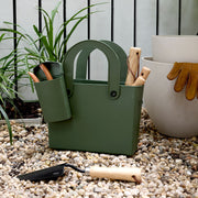 Hachiman | Garden Tool Bag Garden Green with attached tool cup and wooden-handled tools, displayed with leather gloves and planter in a gardening setup.