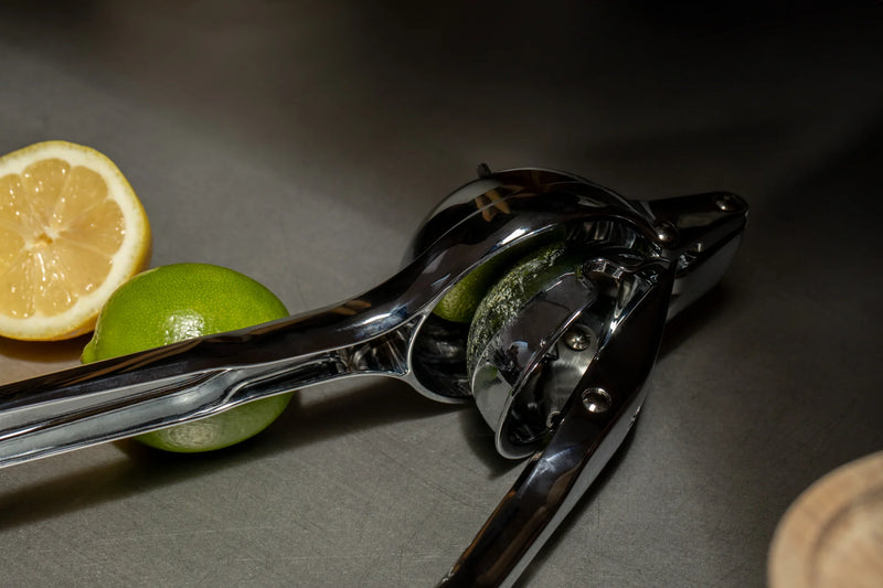 Holcomb Studio | Link Citrus Press alongside fresh citrus fruits, showcasing a quality kitchen tool from Athens Cooks, perfect for efficient juicing.