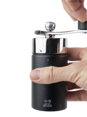 Peugeot | Isen Nutmeg Mill, Matte Black: A compact manual grinder with a chrome top and crank handle, ideal for finely grinding nutmeg safely.