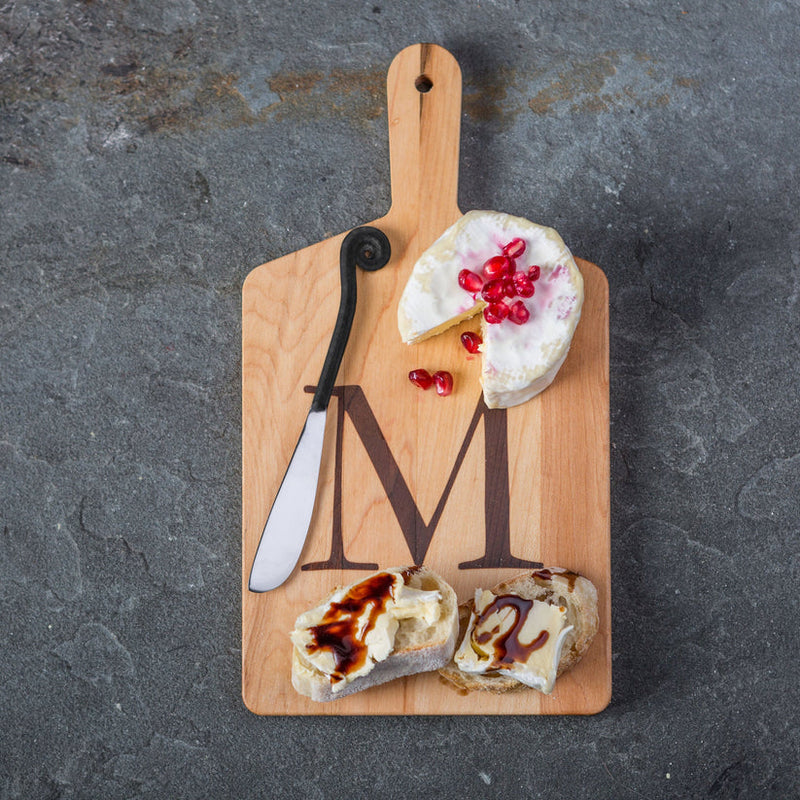 Monogrammed Maple Cheese Board with Letter M, featuring soft cheese with pomegranate arils, crusty bread slices, and a cheese knife, ideal for small gatherings.