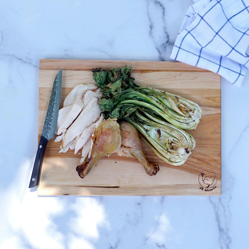 J.K. Adams | Maple Reversible Prep Boards - 16 x 12 with sliced roast chicken, drumsticks, and char-grilled bok choy, highlighting its versatile two-sided design.