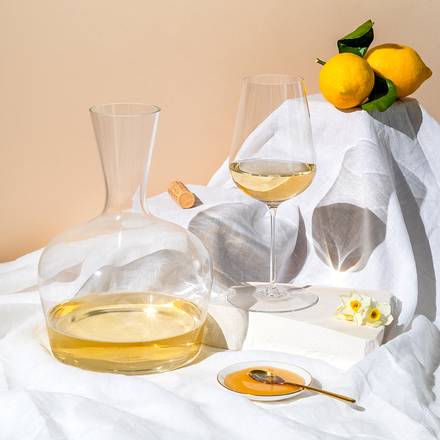 Richard Brendon | Jancis Robinson Original Wine Glass Set of 2 alongside a wine bottle and lemons, showcasing its elegant design for enhancing wine tasting.