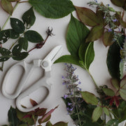 The Floral Society | Japanese Floral Clippers, Citrine, surrounded by cut rose stems and leaves, showcasing their precision craftsmanship ideal for gardening and floral arrangements.