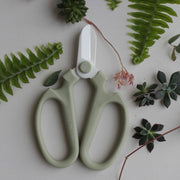 The Floral Society | Japanese Floral Clippers, Citrine with sage-green handles and white blades, surrounded by botanical elements, perfect for precise flower and plant trimming.