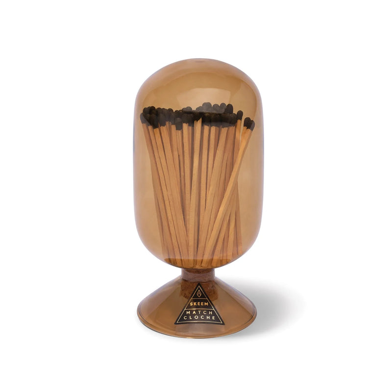 Skeem | Amber Match Cloche: Decorative glass holder with long matches on a pedestal base, featuring a cork top and striker strip, perfect for elegant kitchen display.