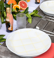 Plate & Pattern | Lemon Chiffon Original Flat Plate Liners on a table with dishware and citrus fruits, showcasing their versatility for trays and platters.