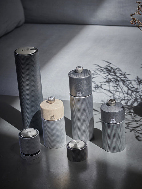 Peugeot | Line Pepper Mill, Aluminum + Beechwood, Carbon Finish, 7 inches, showcased among coordinated grinders, highlighting its modern design and adjustable grind setting.