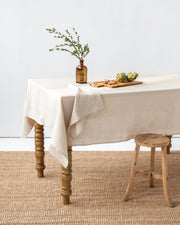 MagicLinen forest green tablecloth, 59x98 inches, with a simple seam finish, ideal for diverse dining settings.
