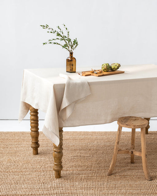 MagicLinen forest green tablecloth, 59x98 inches, with a simple seam finish, ideal for diverse dining settings.