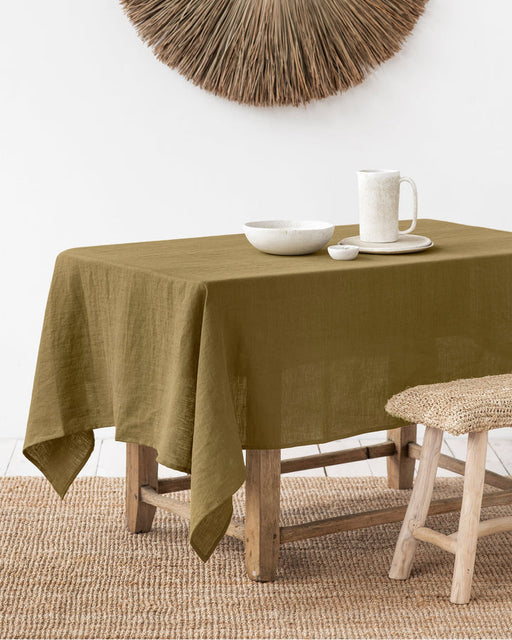 MagicLinen forest green linen tablecloth, 59 x 98 inches, with a simple seam finish, ideal for diverse dining settings, from casual to formal occasions.