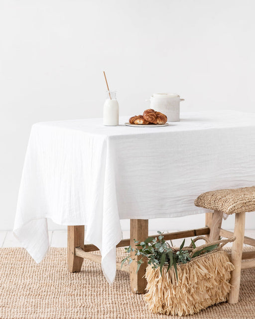 MagicLinen forest green linen tablecloth, 59 x 98 inches, with a simple seam finish, ideal for enhancing both casual and formal dining settings.