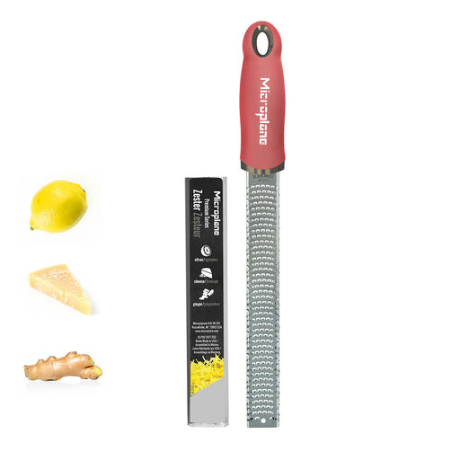 Microplane Premium Zester/Grater with red ergonomic handle, shown with lemon, cheese, ginger, highlighting its versatile use for zesting and grating in culinary tasks.