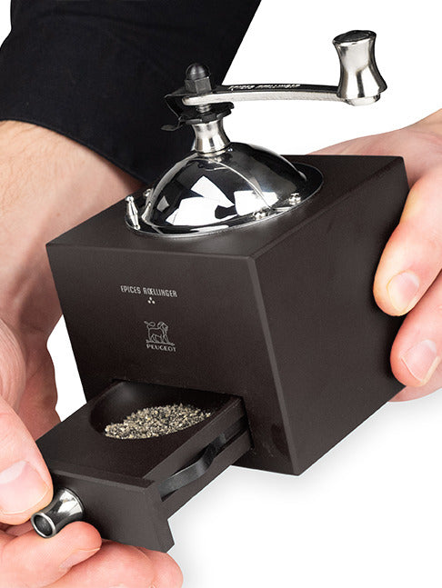 Peugeot | Roellinger Pepper Mill, Chocolate: A hand-cranked, chocolate-stained wood pepper mill with stainless steel crank, featuring a pull-out tray for freshly ground spices.