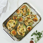 Hestan Provisions | OvenBond Tri-Ply Bakeware featuring roasted cauliflower steaks and onions with herbs and capers, showcasing even heat distribution and stylish design.
