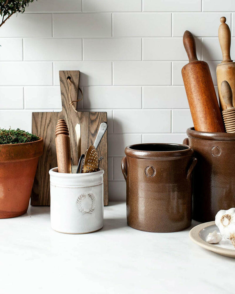 Farmhouse Pottery Agrarian Crocks in 1-2 gallon sizes feature hand-stamped handles and iron-flecked texture, perfect for rustic kitchen decor.