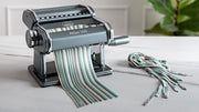 Marcato | Atlas 150 Pasta Maker processing colorful pasta dough, showcasing its manual functionality and precision for making lasagne, fettuccine, and tagliolini at home.