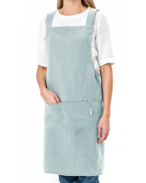 MagicLinen Pinafore Cross-Back Linen Apron in Dusty Blue, features criss-cross straps and side pockets, ideal for cooking or gardening.