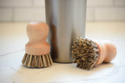 Earth & Nest | Pot and Pan Brush made of beech wood and union fiber, shown next to a cup, ideal for cleaning cookware.