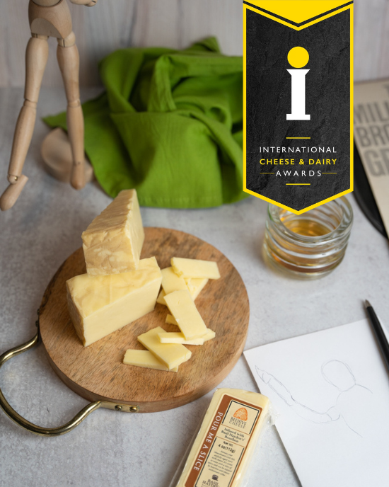 Beehive Cheese Co. LLC | Pour Me A Slice - 4 oz Wedge on wooden surface, showcasing its artful aging and bourbon infusion.