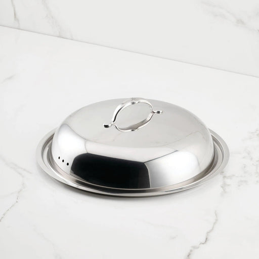 Hestan Provisions | Stainless Steel Lids Dome, 14 with ergonomic handle on a matching tray, ideal for maintaining heat and flavor in culinary settings.