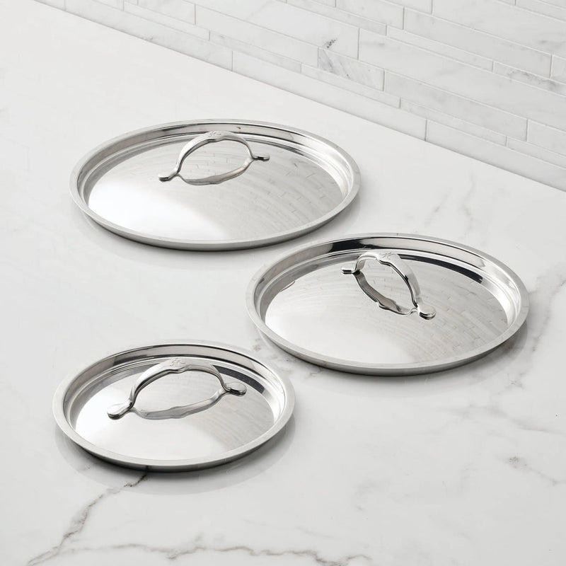 Hestan Provisions | Stainless Steel Lids Large, 12.5, displayed on a marble surface, showcasing ergonomic handles and durable tri-ply construction for optimal cooking performance.