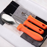 Messermeister | Pumpkin Meister Carving Set with orange handles: two-tine fork, serrated knife, and scalloped spoon on checkered cloth, ideal for precision pumpkin carving.