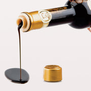 Reale | Classic Balsamic Glaze pouring from a bottle, showcasing its smooth texture, ideal for enhancing dishes with rich, tangy flavor.