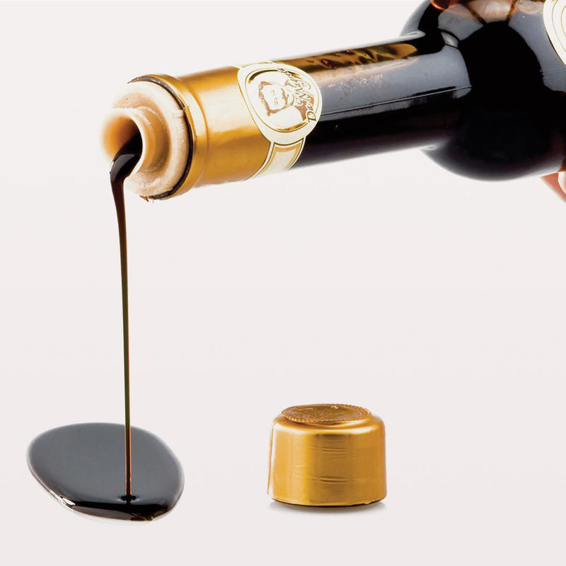 Reale | Classic Balsamic Glaze pouring from a bottle, showcasing its smooth texture, ideal for enhancing dishes with rich, tangy flavor.