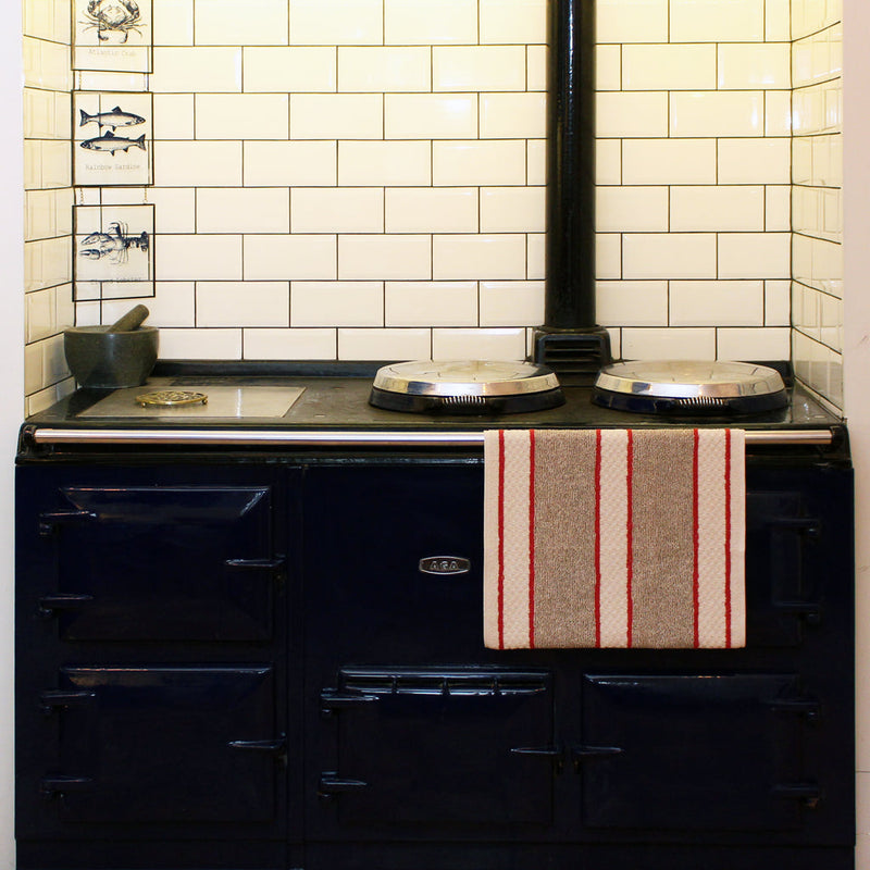 Earth & Nest | Red Range Towel hanging on a stove rail, featuring a popper fastening to prevent slipping, ideal for keeping towels clean and dry.