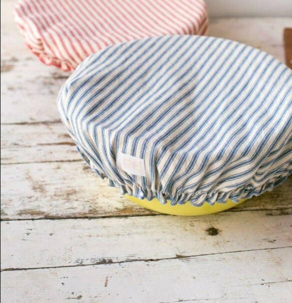 Dot and Army | Reusable Bowl Covers - Denim Blue Ticking snugly fitting on a yellow bowl, showcasing their stylish, sustainable design for protecting and covering food.
