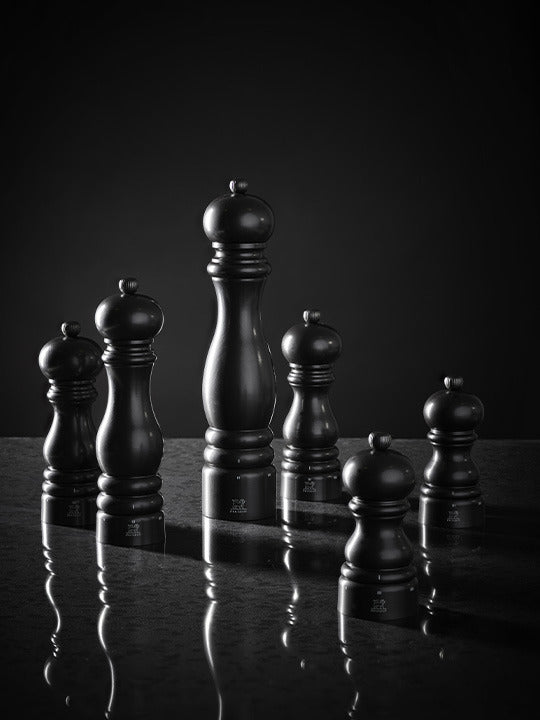 Peugeot | Paris u'Select Pepper Mill, Satin Black, elegantly displayed among various-sized mills, showcasing its adjustable grind feature for fine-dining precision.