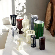 Sir|Madam Empire Mixer, Tuxedo, featuring elegant cut-out sleeves on tumblers, goblets, and a pitcher, inspired by 1920s skyscrapers, displayed on a wet countertop.