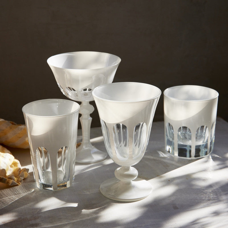 Sir|Madam Rialto Chalk glassware lifestyle shot showing all four shapes — Tumbler, Coupe, Tulip, and Old Fashion — styled on a linen-draped tabletop