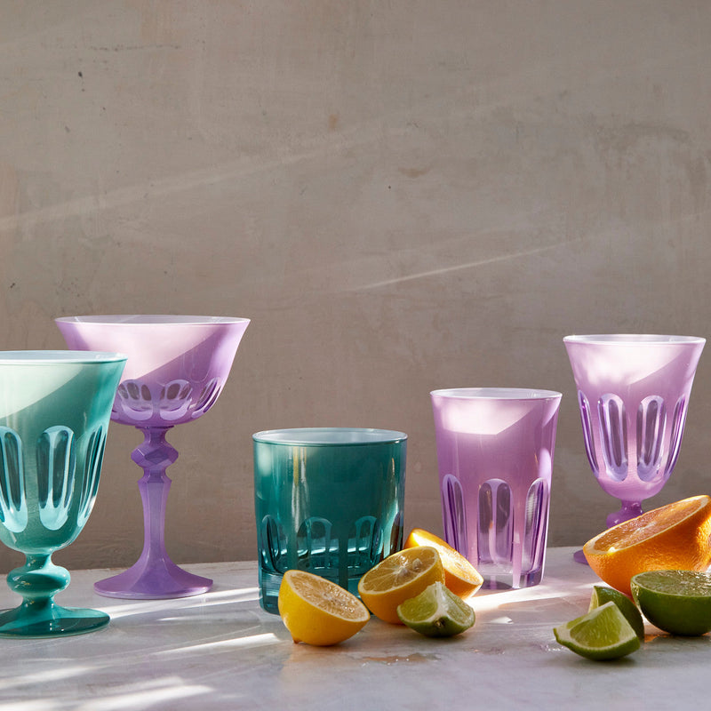 Sir|Madam Rialto Lupine coupe styled with a Menthe goblet, teal tumbler, lupine tumbler, and lupine goblet alongside fresh citrus