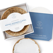 Plate & Pattern Seagrass Plates, eco-friendly with wood bottom, beautifully woven, perfect for dining décor. Featured in a box, ideal for Athens Cooks' curated kitchen collection.