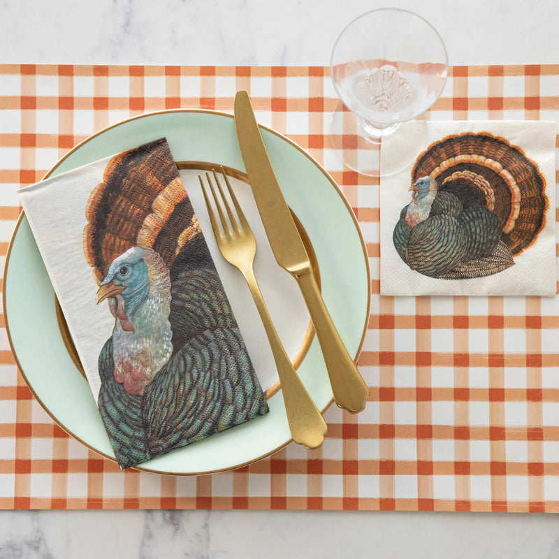 Thanksgiving place setting featuring Hester & Cook's Heritage Turkey Collection, showcasing turkey-printed napkins and paper placemats with gold-accented mint-green plate.