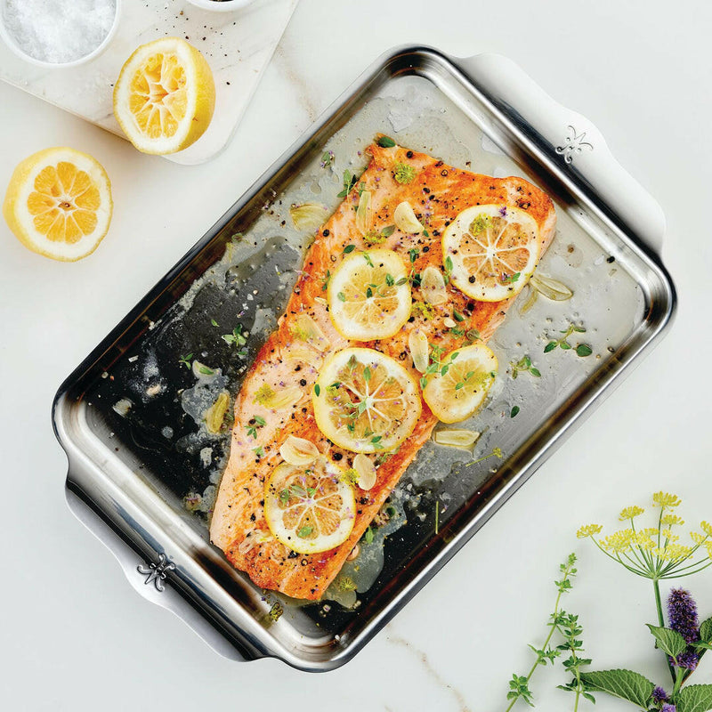 Hestan Provisions OvenBond Bakeware showcasing a seasoned salmon fillet with lemon and herbs, highlighting the pan's durable, triple-bonded stainless steel construction.